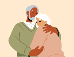 An older man embraces an older woman, kissing her forehead.