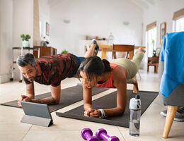A man and a woman doing yoga in their living room