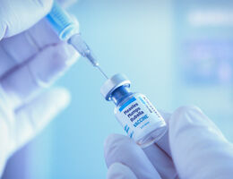 A vial of measles vaccine and a syringe.