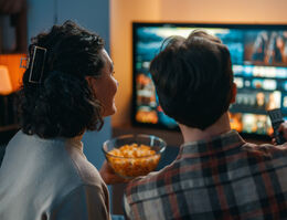 A couple selects a movie to stream.