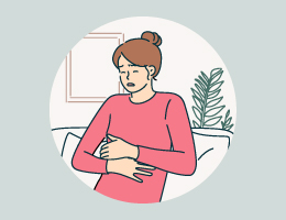 A woman holds her stomach in pain.
