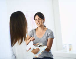 A patient gestures as she talks to a provider