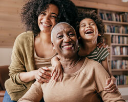 A child, mother and grandmother smiling and laughing.