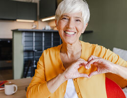  A woman making a heart shape with her hands.