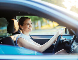  A smiling woman in a car.