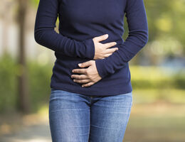 A woman's arms pressed to her stomach.
