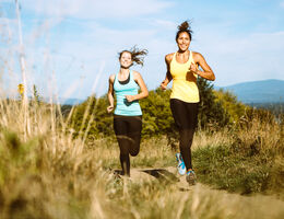 Two women running on a trail
