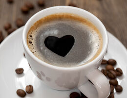 Foam forms a heart shape in a cup of coffee.