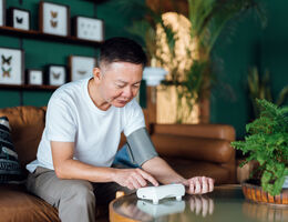 A man uses a home blood pressure monitor.